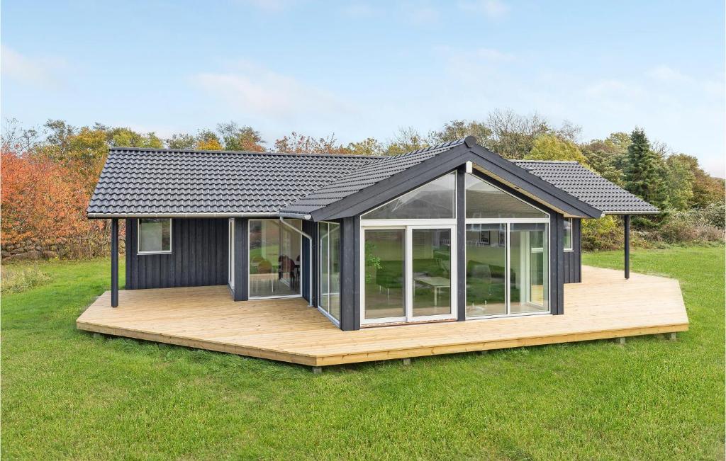 a black house with a deck in a field at Beautiful Home In Hasle With House Sea View in Hasle