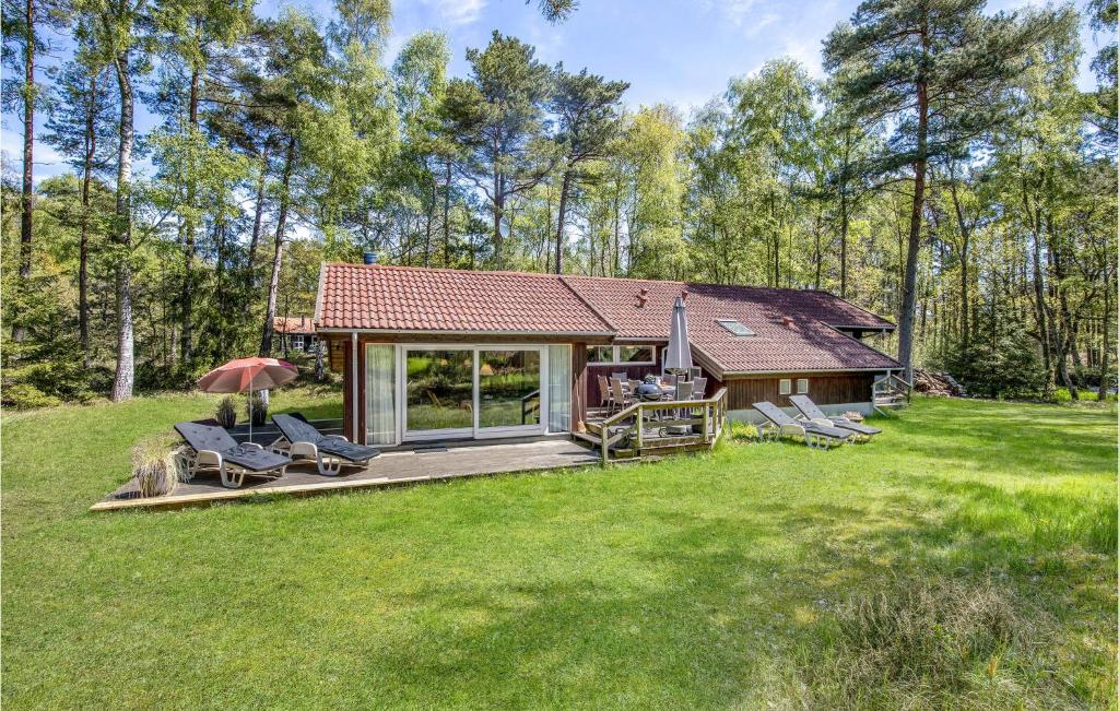 una casa con terraza en medio de un patio en Cozy Home In Nex With Sauna, en Bedegård