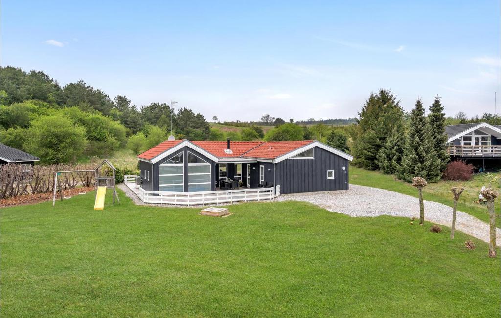 エーベルトフトにあるStunning Home In Ebeltoft With Kitchenの庭の赤屋根の黒家