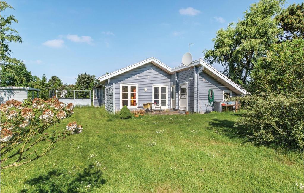 a small house in a yard with a grass field at Beautiful Home In Store Fuglede With Kitchen in Store Fuglede