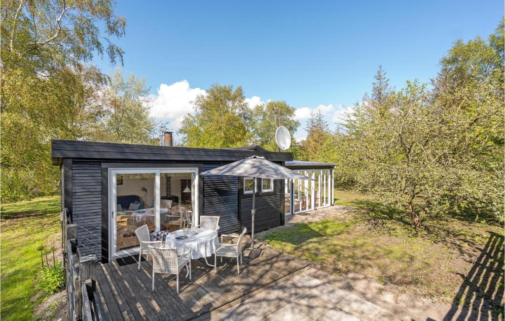 a black tiny house with a table and chairs at Holiday Home Sneppevej Rødby Denm in Kramnitse