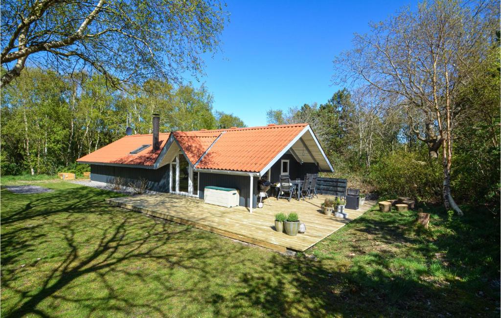 a house with an orange roof and a wooden deck at Nice Home In Thyholm With 4 Bedrooms, Sauna And Wifi in Thyholm