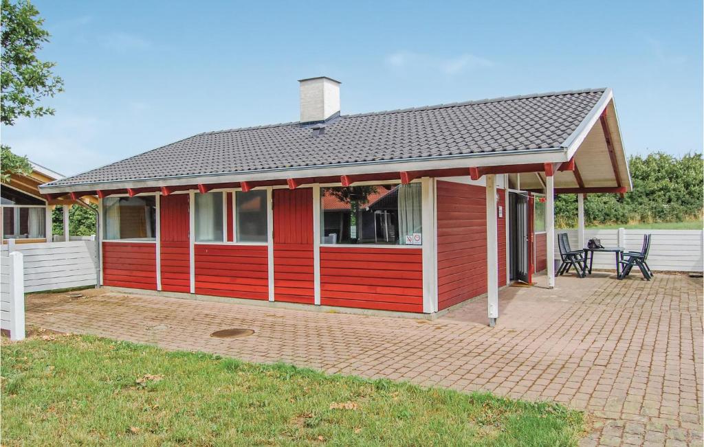 une maison rouge avec une terrasse en briques devant elle dans l'établissement Golfparken, à Danland Løjt