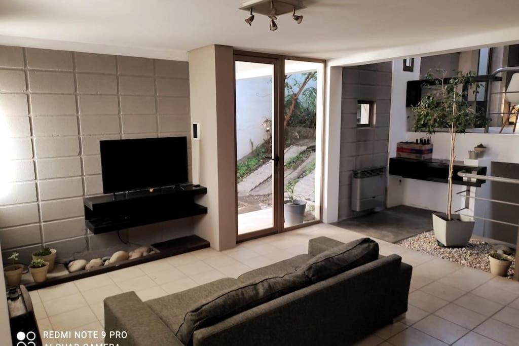 sala de estar con sofá y TV de pantalla plana en Triplex de diseño , amplio , luminoso y céntrico en Carmen de Patagones