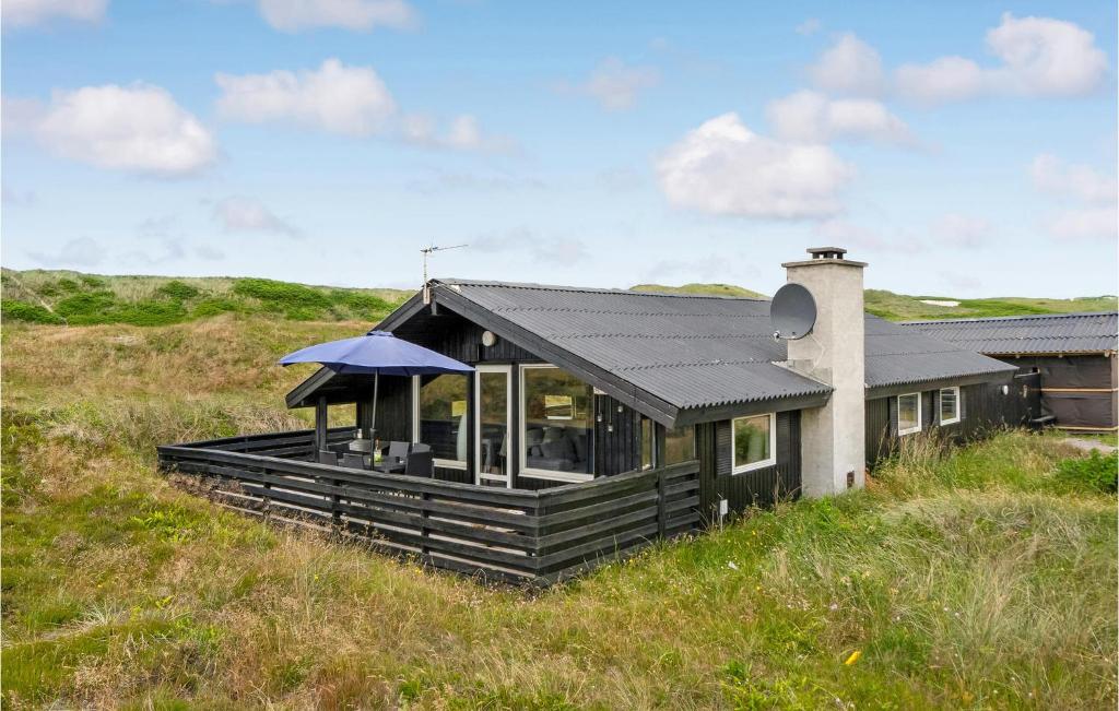 a house on top of a grassy hill at 3 Bedroom Cozy Home In Hvide Sande in Bjerregård