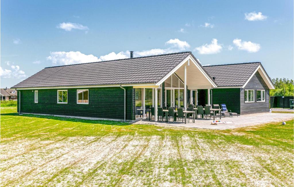 una casa verde con césped delante en Lovely Home In Idestrup With Wifi, en Bøtø By