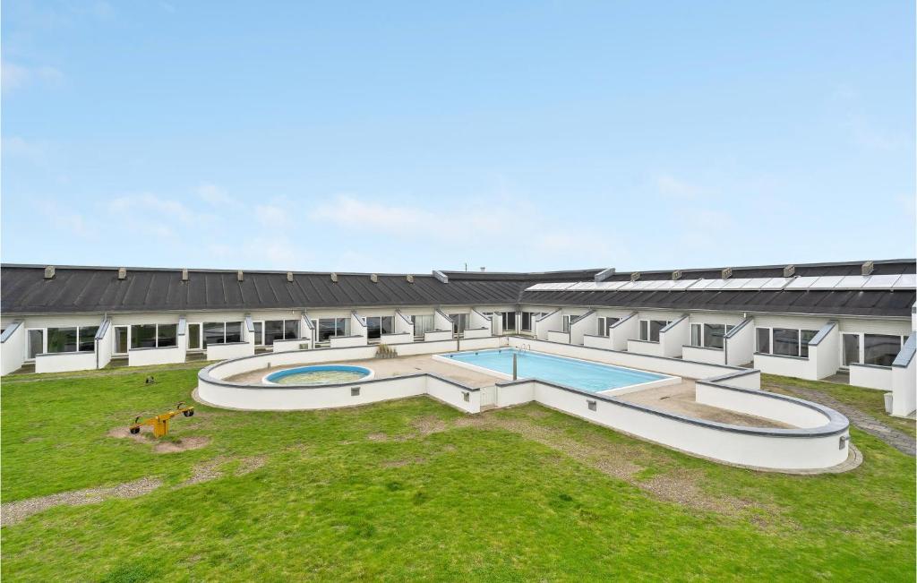 ein Gebäude mit zwei Swimmingpools im Hof in der Unterkunft Feriehotel Tranum Klit in Brovst