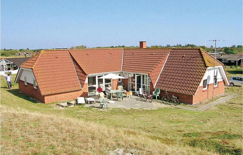 una casa con techo rojo en un campo en Amazing Home In Fan With 5 Bedrooms, Sauna And Wifi, en Fanø