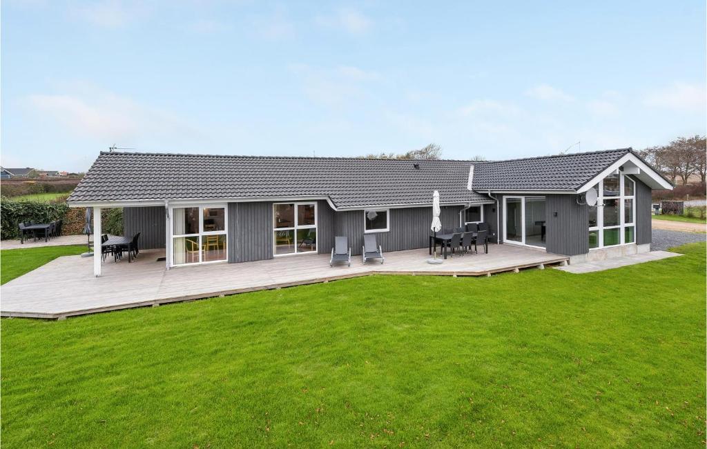a house with a deck and a green lawn at Holiday Home Kildebakken Vinderup V in Vinderup