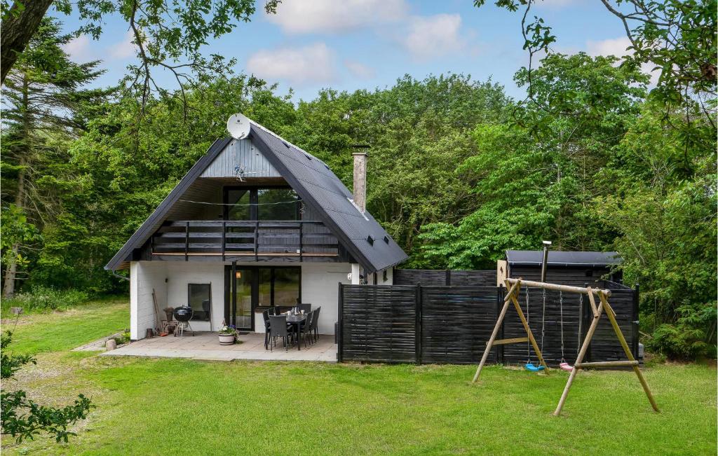 une petite maison avec un toit en gambrel et une aire de jeux dans l'établissement Cozy Home In ster Assels With Sauna, à Øster Assels