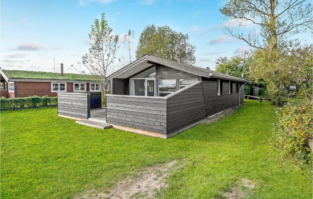 a small black house on a grassy yard at Awesome Home In Haderslev With 2 Bedrooms And Wifi in Diernæs