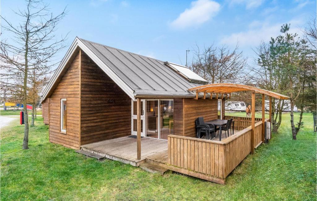 a wooden cabin with a deck with a table at Stunning Home In Hanstholm With Wifi in Hanstholm
