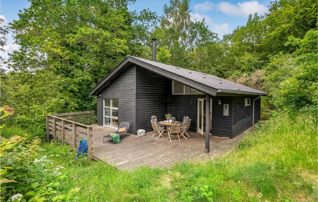 eine schwarze Hütte mit einer Terrasse und einem Tisch in der Unterkunft Pet Friendly Home In Gistrup With Wifi in Gistrup