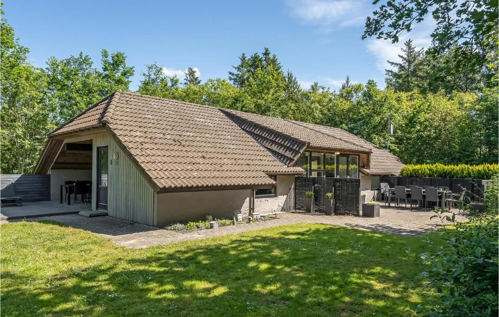 una casa con techo a dos aguas y patio en Lovely Home In Oksbl With Swimming Pool, en Oksbøl