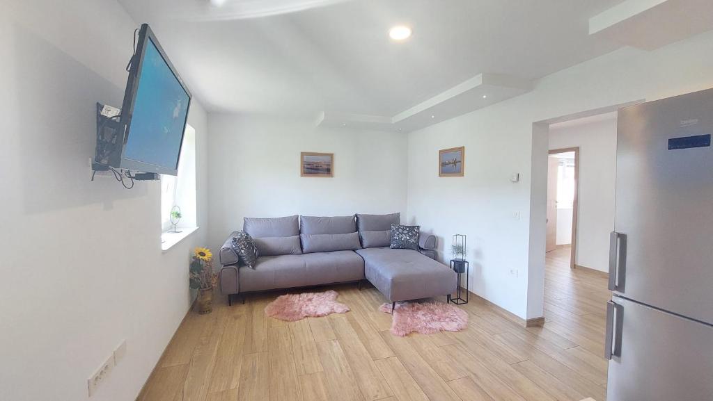 ein Wohnzimmer mit einem Sofa und einem Flachbild-TV in der Unterkunft New Istriaexperience in Koper