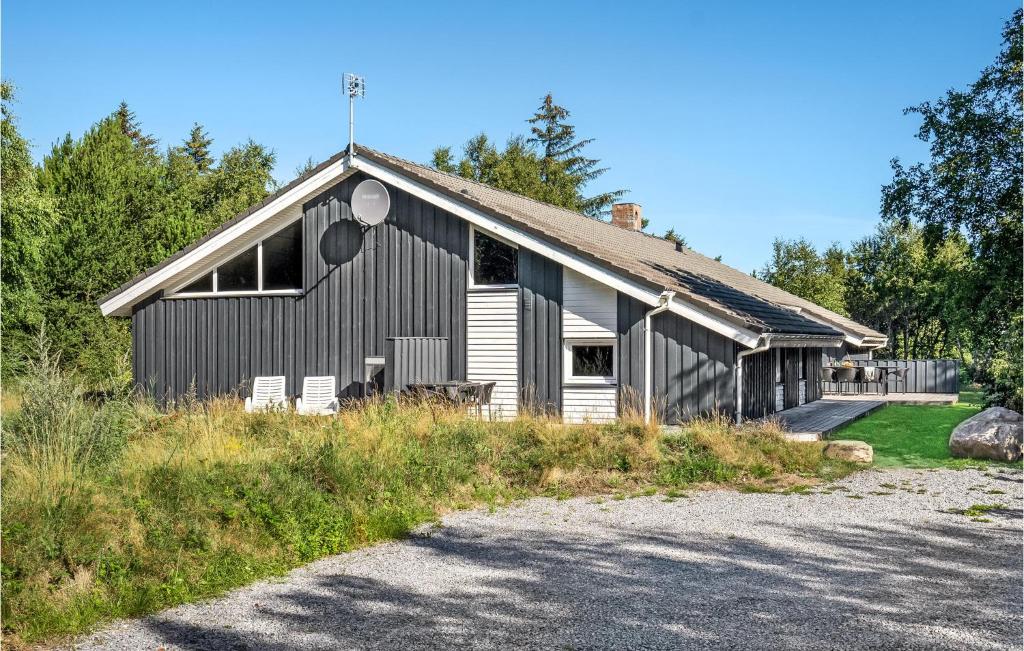 a black building with two white chairs in front of it at Awesome Home In Hirtshals With 6 Bedrooms, Sauna And Wifi in Hirtshals