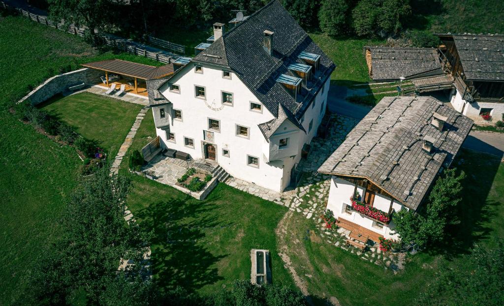 een uitzicht op een groot wit huis met een dak bij Ansitz Bergrichter in Cadipietra