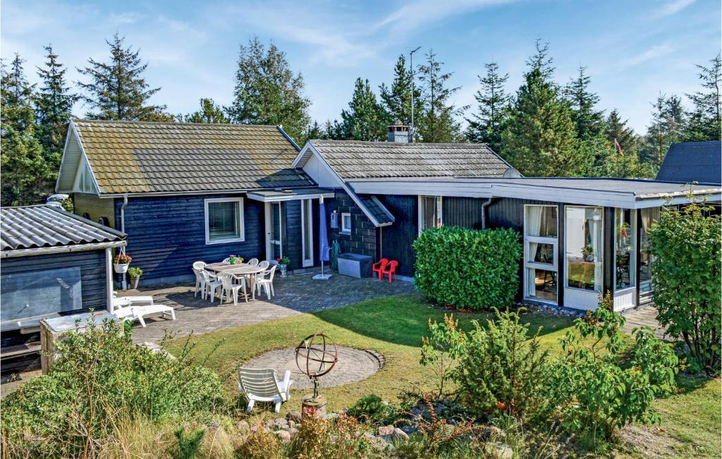 a blue house with a patio and a yard at Holiday Home Ydunvej Ebeltoft in Ebeltoft
