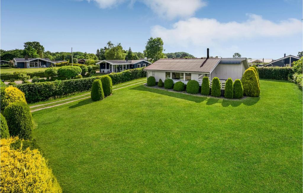 une grande pelouse avec une maison et des buissons dans l'établissement Nice Home In Egernsund With House A Panoramic View, à Egernsund