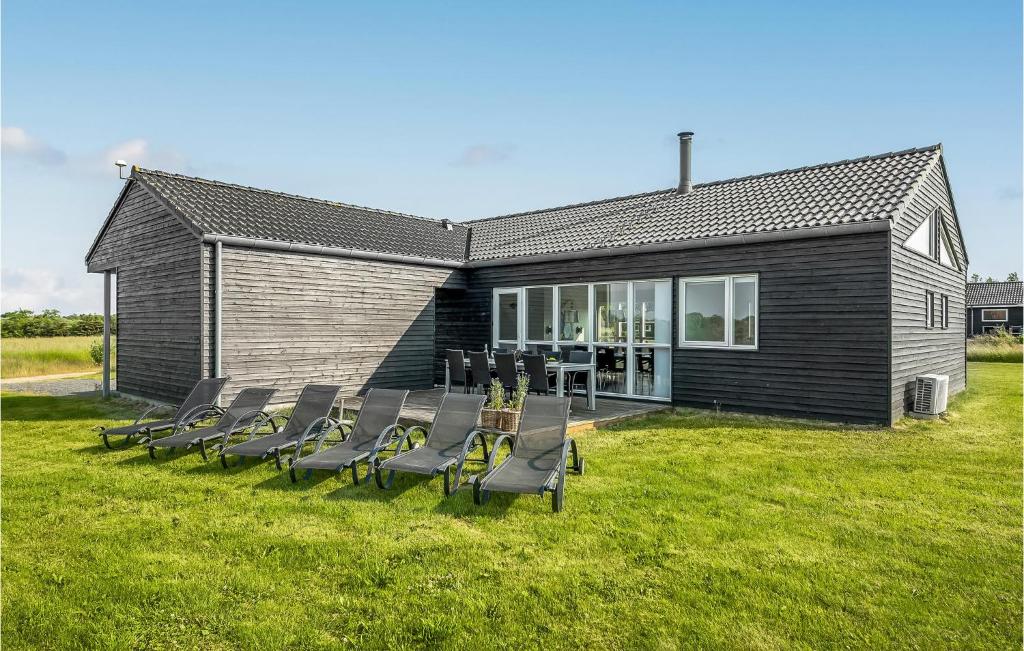 4 Bedroom Beautiful Home In Haderslev في Årø: جلسة مجموعة كراسي أمام المبنى