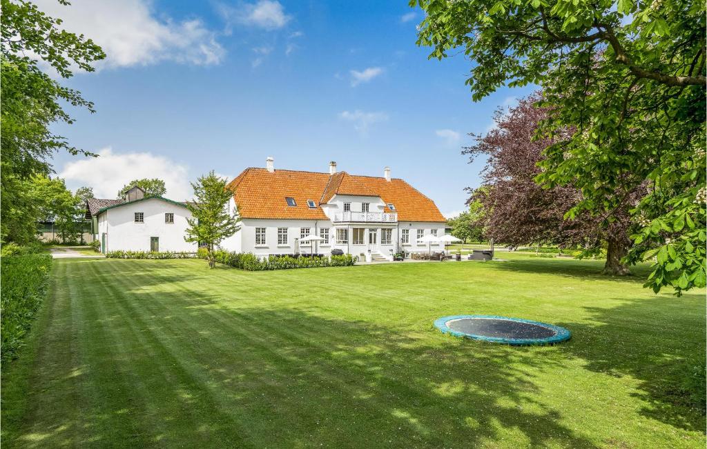 a large white house with a frisbee in the yard at Rimersgaard in Horslunde