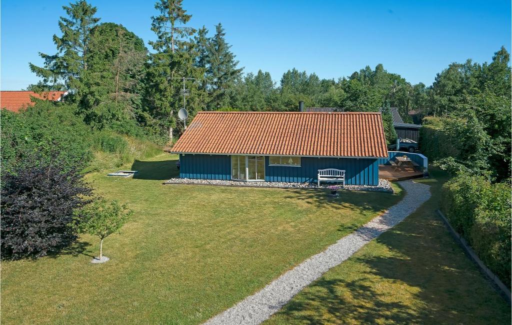 ein blaues Haus mit rotem Dach im Hof in der Unterkunft Stunning Home In Middelfart With Sauna in Voldby