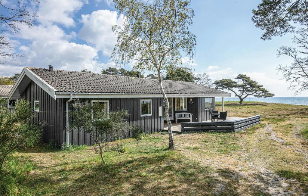 una pequeña casa en una colina con el océano en el fondo en Spaetten, en Snogebæk