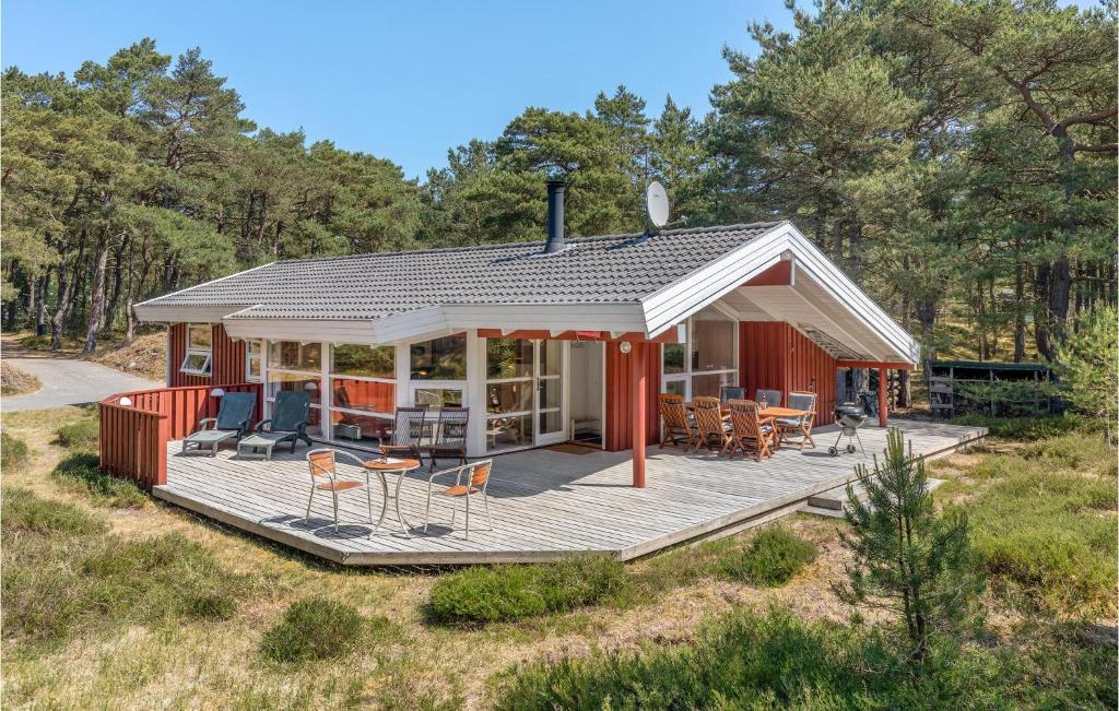 a small red house with a deck in a field at Godt Gemt in Vester Sømarken