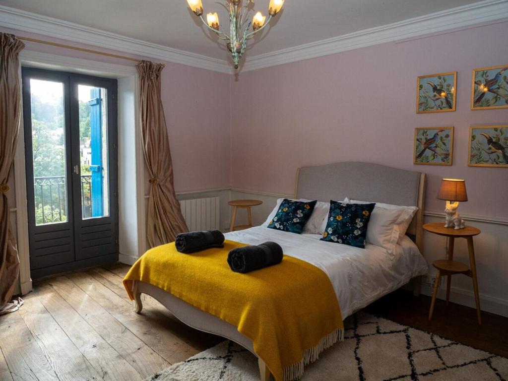 een slaapkamer met een bed met een gele deken erop bij Chez Dizjon, A Stunning Canalside Property in Josselin