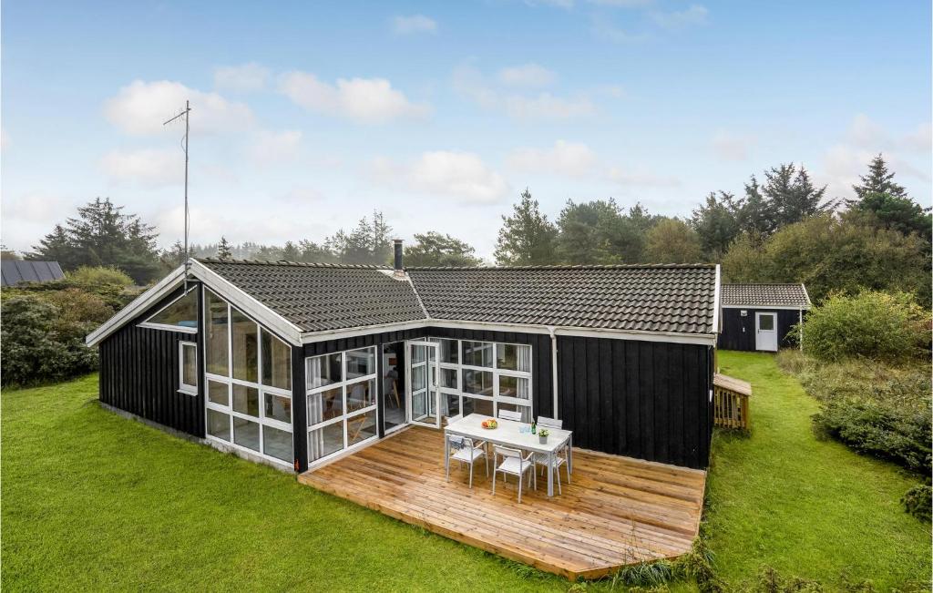 ヒアツハルスにあるAwesome Home In Hirtshals With 4 Bedrooms, Sauna And Wifiの木製デッキ付き白黒家屋