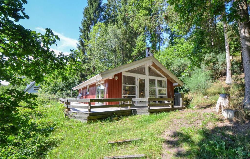 エーベルトフトにあるStunning Home In Ebeltoft With 1 Bedroomsの木々の木々が茂る赤い小屋