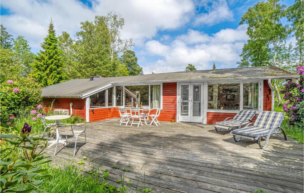 una casa rossa con terrazza con sedie e tavolo di 5 Bedroom Amazing Home In Rrvig a Rørvig