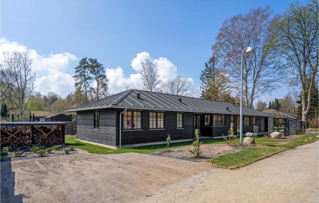 una casa con una casa negra con entrada en Lovely Home In Hornbk With Kitchen, en Hornbæk