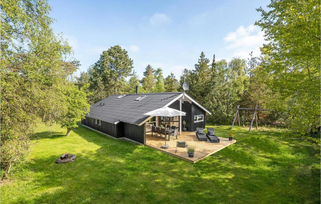 a black cabin in the middle of a yard at Nice Home In Knebel With 4 Bedrooms, Sauna And Wifi in Knebel