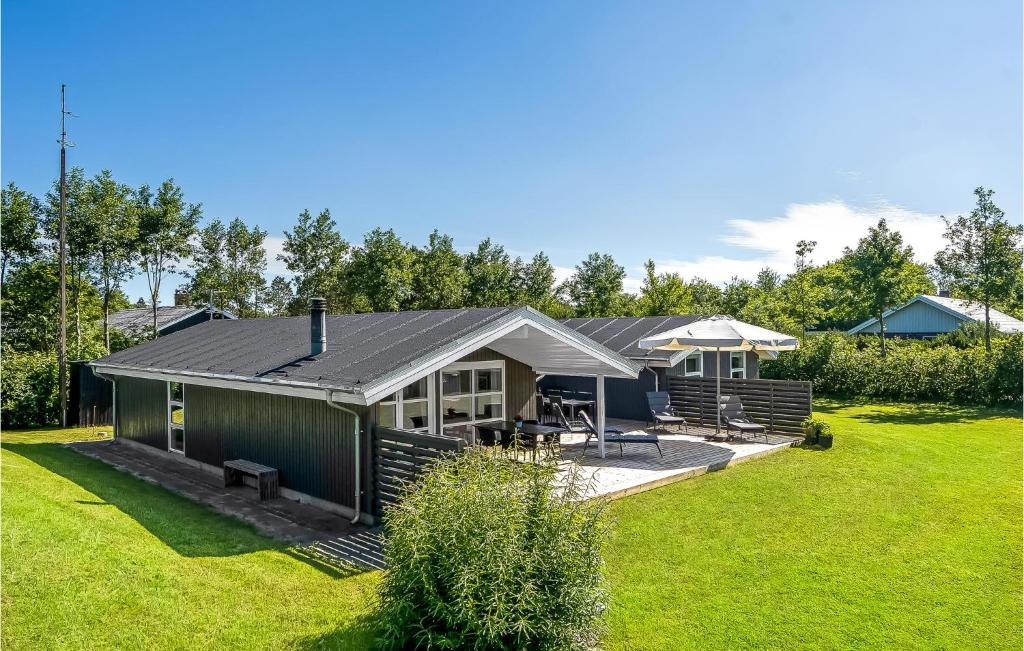 a house with a green yard with a building at 4 Bedroom Beautiful Home In Blvand in Blåvand
