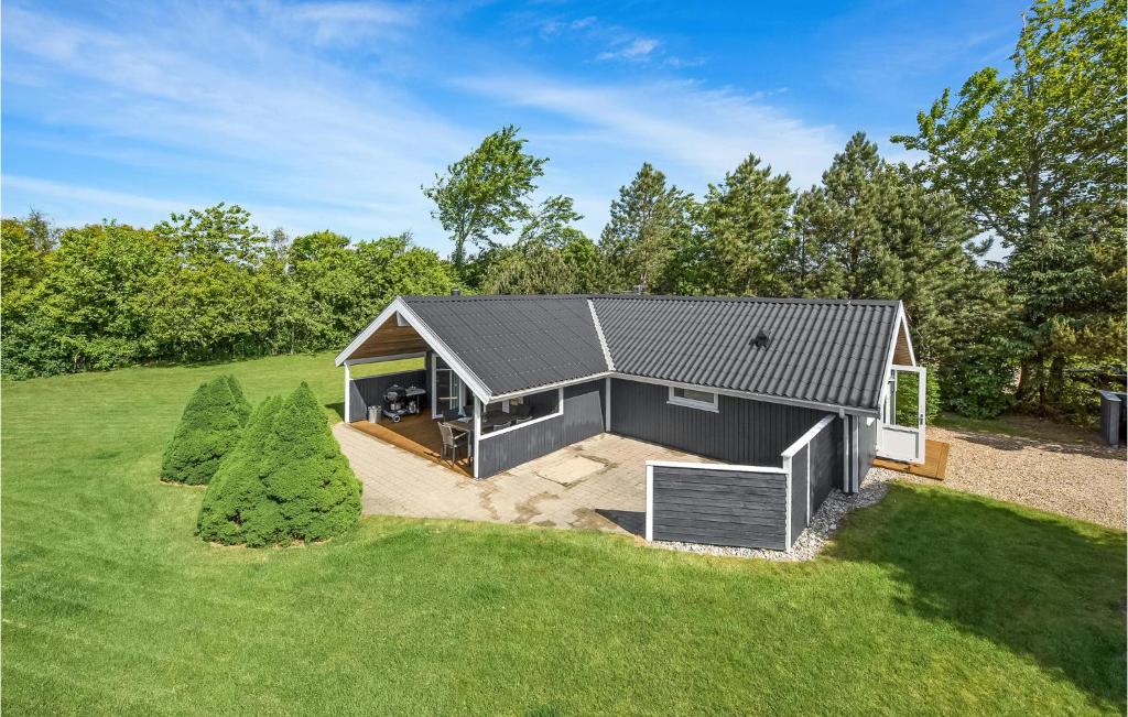 a small house with a black roof on a field at Amazing Home In Tarm With Wifi in Hemmet