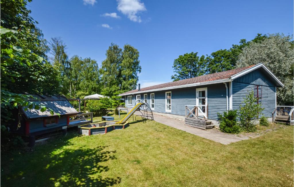 a blue house with a yard with a playground at Beautiful Home In Vig With 4 Bedrooms, Sauna And Wifi in Vig