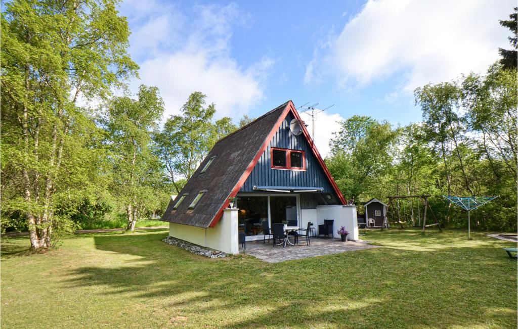 エーベルトフトにあるBeautiful Home In Ebeltoft With 3 Bedroomsの草原の赤屋根納屋