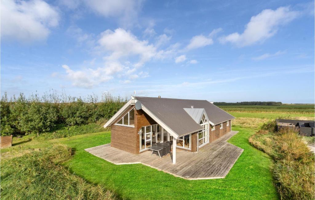 uma pequena casa de madeira num campo relvado em Stunning Home In Hvide Sande With House A Panoramic View em Havrvig