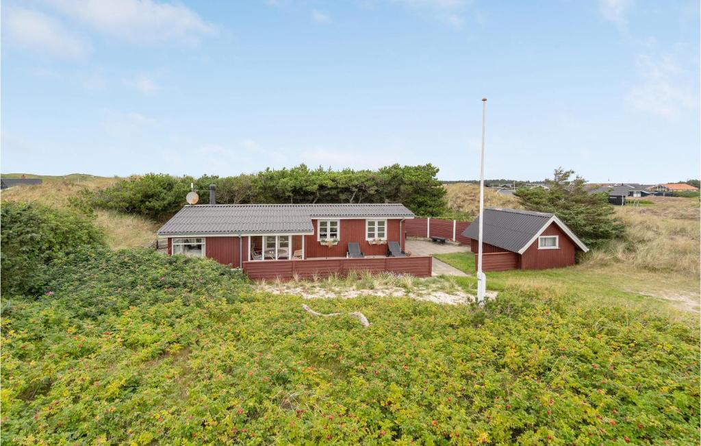 Bjerregårdにある2 Bedroom Cozy Home In Hvide Sandeの丘の脇の赤い家