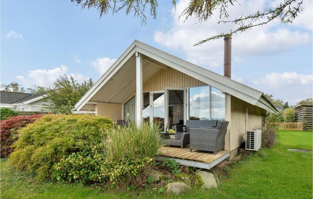 een klein huis met een veranda en een terras bij Awesome Home In Kge With House Sea View in Valløby