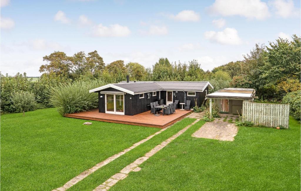 a black tiny house in a garden with a deck at Stunning Home In Assens With Kitchen in Assens