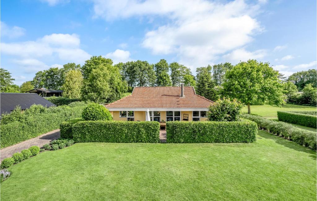 a house with hedges in front of a yard at Gorgeous Home In Hejls With Kitchen in Hejls