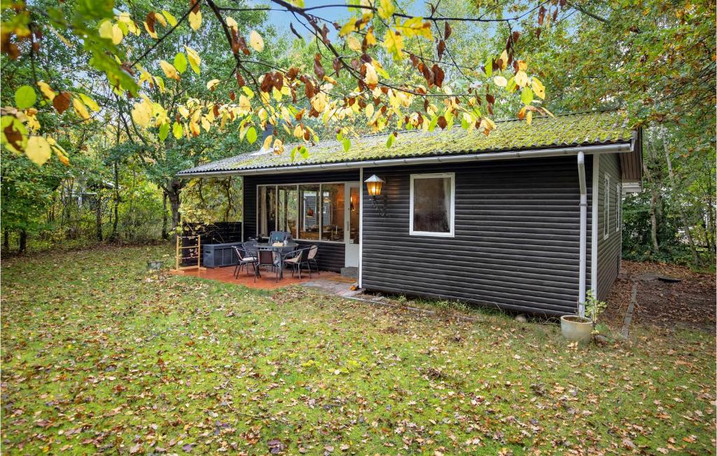 a small black cabin with a porch and a patio at 2 Bedroom Pet Friendly Home In Rnne in Rønne