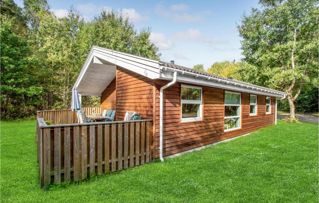 a wooden cabin with a fence in the grass at 4 Bedroom Amazing Home In Hasle in Hasle