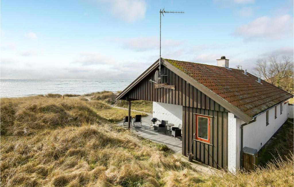 a small house on a hill next to the ocean at Beautiful Home In Aakirkeby With Wifi in Åkirkeby