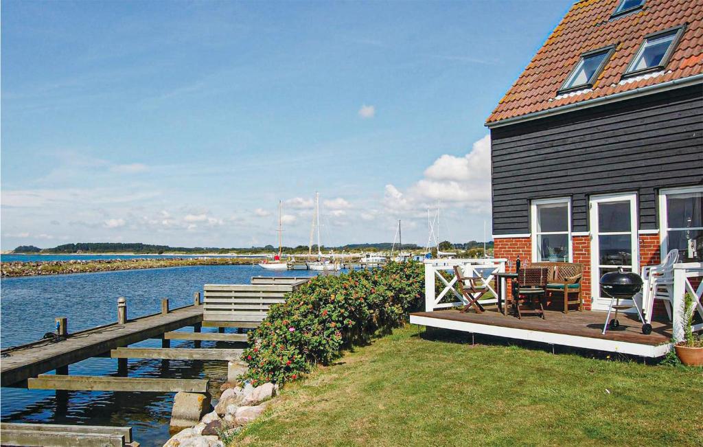 a house with a dock next to a body of water at Cozy Apartment In Borre With House Sea View in Borre