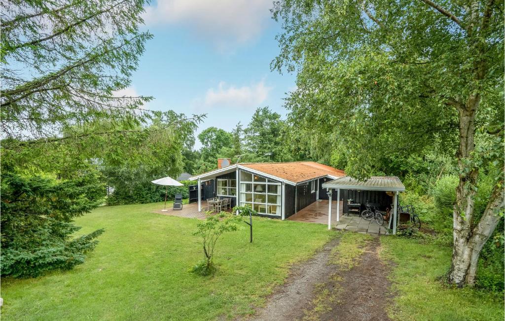 a house in the middle of a yard at Four-Bedroom Holiday Home In Stege in Stege