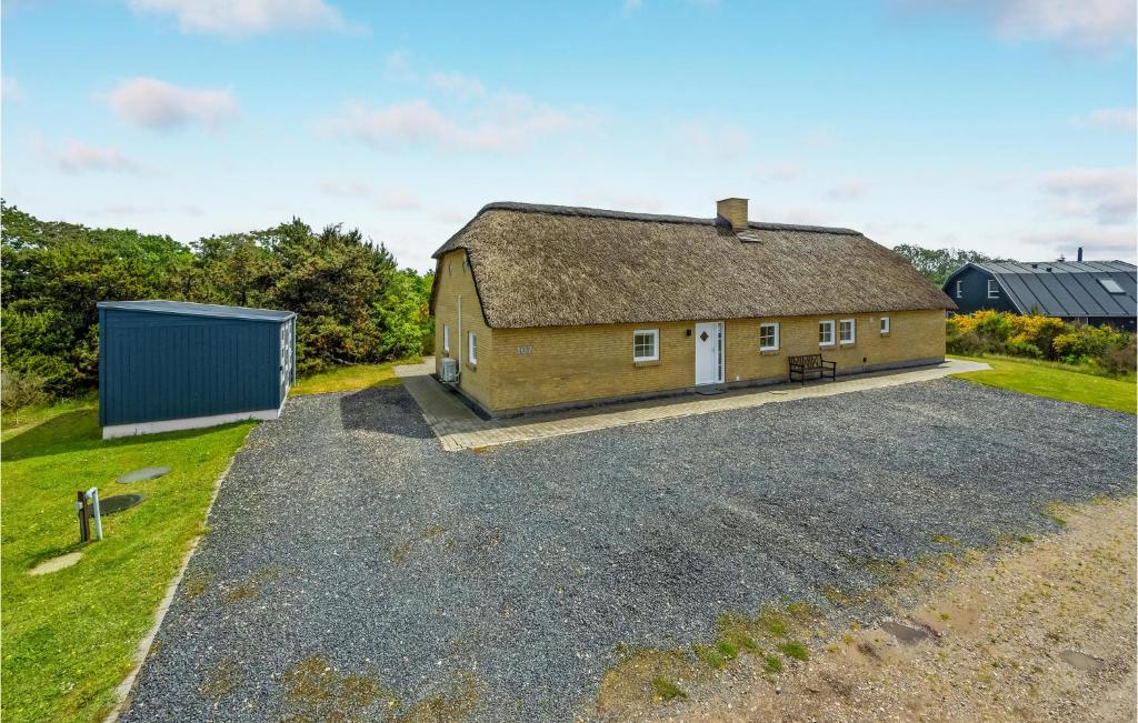 a house with a thatched roof and a gravel driveway at Stunning Home In Skjern With Kitchen in Lem
