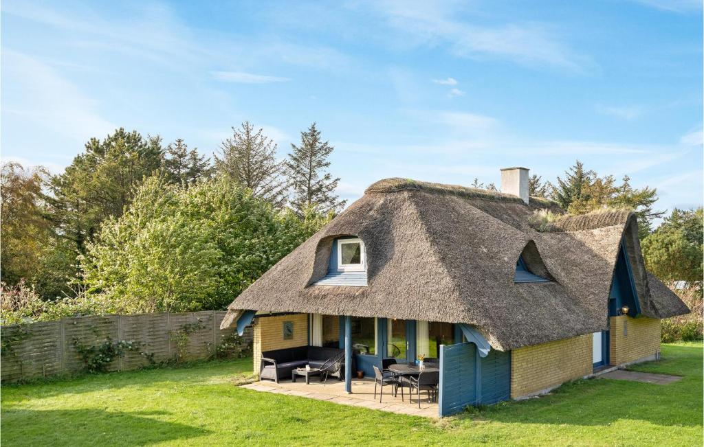 Cette maison au toit de chaume dispose d'une terrasse. dans l'établissement Awesome Home In Thyholm With House Sea View, à Thyholm